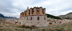 View from the apse of a medieval church in Montalbán, with towers and mountain landscape.