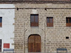 Stone palace facade with wooden doors and windows.