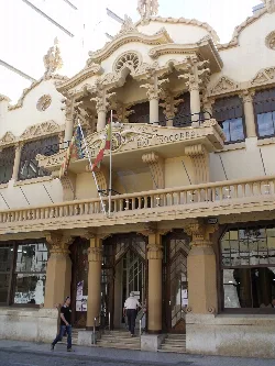 Fassade eines Gebäudes mit Säulen und Flaggen in Sueca.