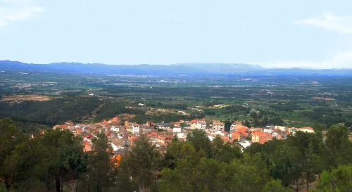 Vista de Rasquera con casas y campo en el fondo.