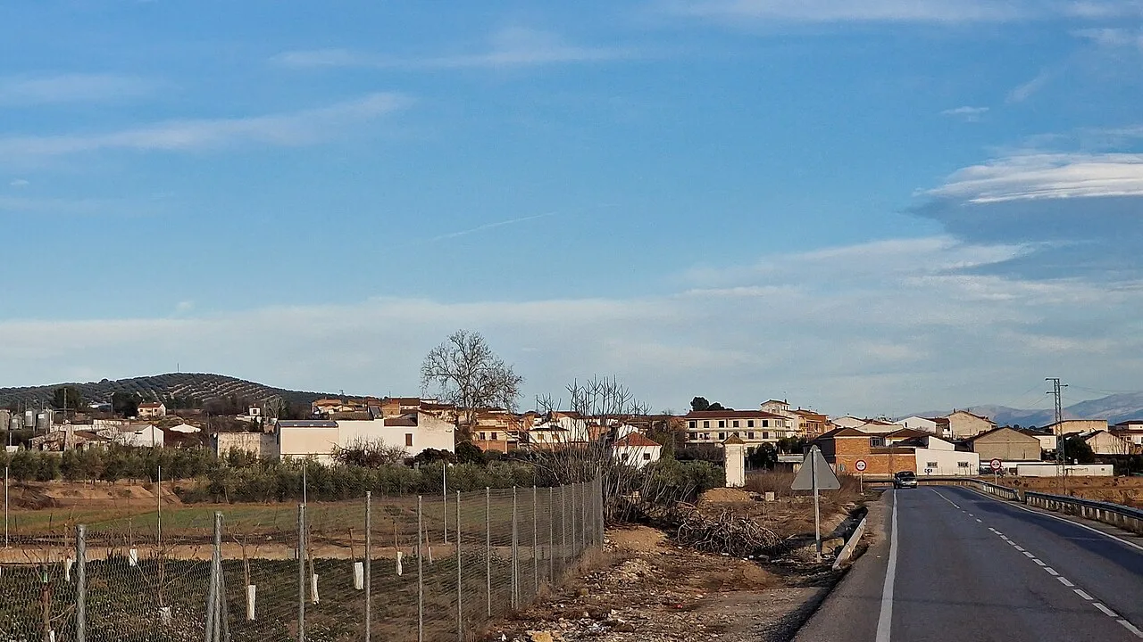 Landscape of Villanueva Mesía seen from the road with houses and blue sky.