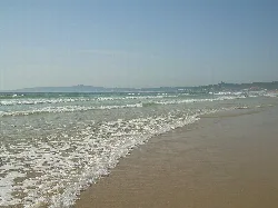 View of Lanzada Beach with waves and golden sand.