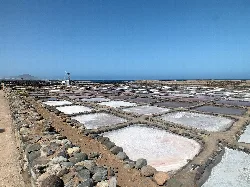 Salt flats with pools and stone walls in a dry landscape