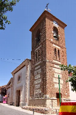 Brick bell tower of the parish church with clock in Quismondo.