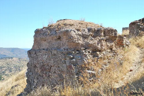 Restos de un muro de piedra en un paisaje seco y montañoso.
