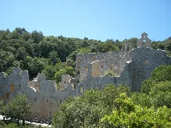 Ruins of a convent in a green, hilly setting.