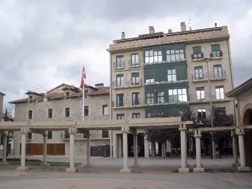 Multi-story building with columns in the square of Huarte Navarra.