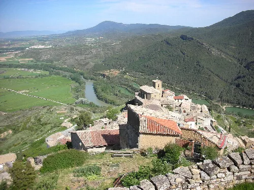 Vista general de Gallipienzo con el río Aragón y montañas en el fondo.