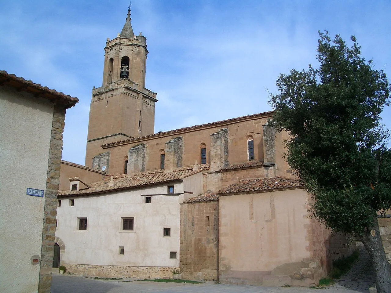 Church of Miravete de la Sierra with tower and stone facade.