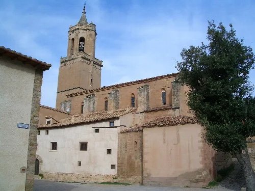 Kirche von Miravete de la Sierra mit Turm und Steinfassade.