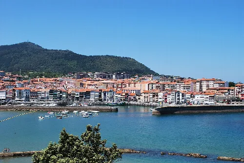 Vista del puerto y la ciudad de Lekeitio con montañas al fondo.