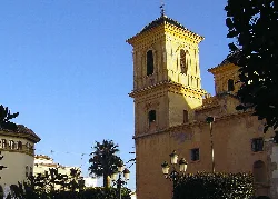 Church of the Assumption in Huércal-Overa with tower and yellow facade.