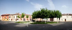 Square with trees and houses in Valdeolmillos.