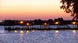Mineral pier with lights reflected in the water at sunset in Huelva.