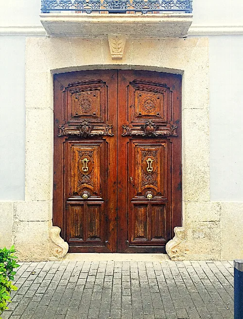 Puerta de madera con detalles decorativos en Castellón de Rugat.