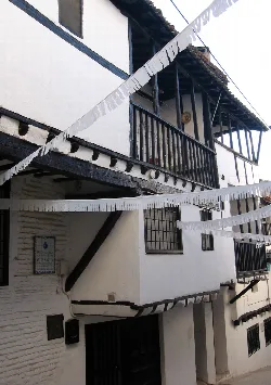 White house with wooden balconies and banners in Mira, Cuenca.