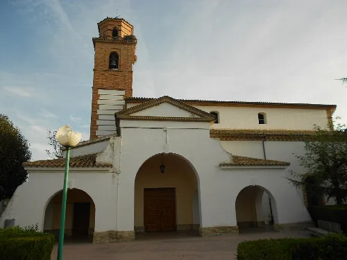 Weiße Kirche mit Turm und Bögen in Tardienta.