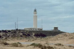Lighthouse in a landscape of dunes and sand at Cape Trafalgar.