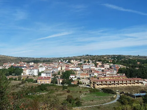 Panoramablick auf Peguerinos mit Häusern und Hügeln im Hintergrund.