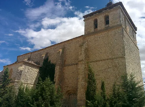 San Miguel Church with tower and stone walls in Requena de Campos.