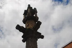 Stone column with a town pillar on top in the square of Castillo de Bayuela.