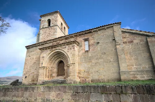 Iglesia de piedra con torre y arco románico en Valdeolea, Cantabria.