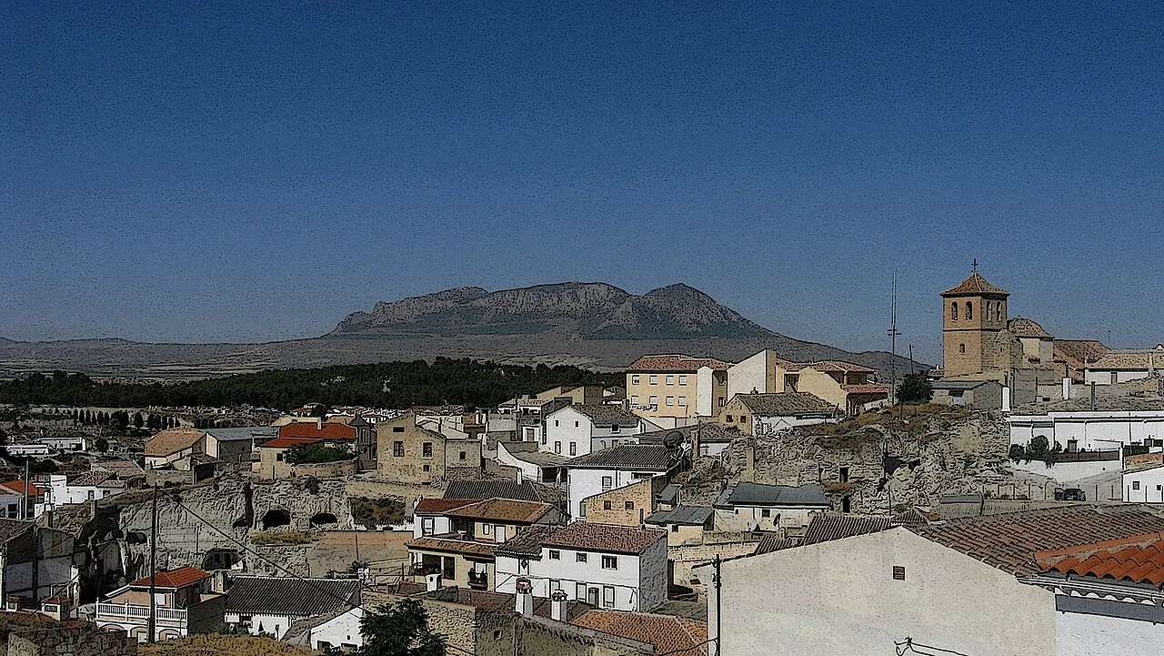 Blick auf Häuser und einen Glockenturm mit einem Berg im Hintergrund