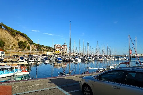 Hafen mit Booten und einem Auto im Vordergrund in Arenys de Mar.