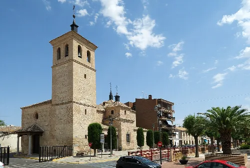 San Andrés Apóstol church with tower and stone facade in Villaluenga de la Sagra.
