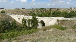 Puente de piedra con arcos en un paisaje natural en Arévalo.