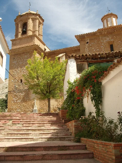 Vista de una calle de Foz-Calanda, con la Iglesia de San Juan Bautista al fondo