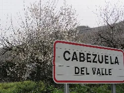 Eingangsschild nach Cabezuela del Valle mit blühenden Bäumen.
