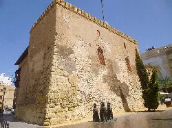 Torre de la Calahorra en Elche, con muros de piedra y ventanas pequeñas.