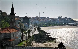 Vista del pueblo con iglesia, paseo y playa en Puerto del Son