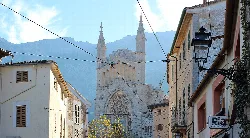 Cathedral in Sóller with mountains and narrow streets.