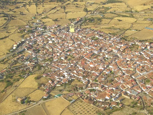 Luftaufnahme einer Stadt mit engen Straßen und roten Ziegeldächern.