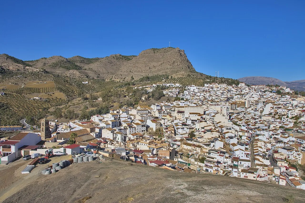 Vista de casas blancas en un pueblo rodeado de montañas.