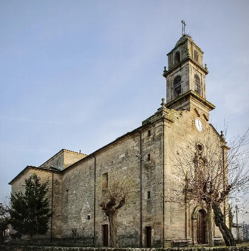 Kirche von Larouco mit Turm und Uhr an der Fassade.