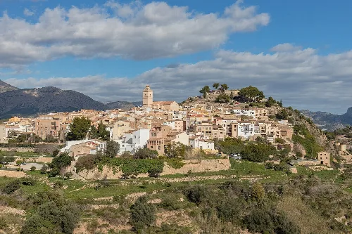 Panoramablick auf Polop mit weißen Häusern und einer Kirche auf dem Hügel.