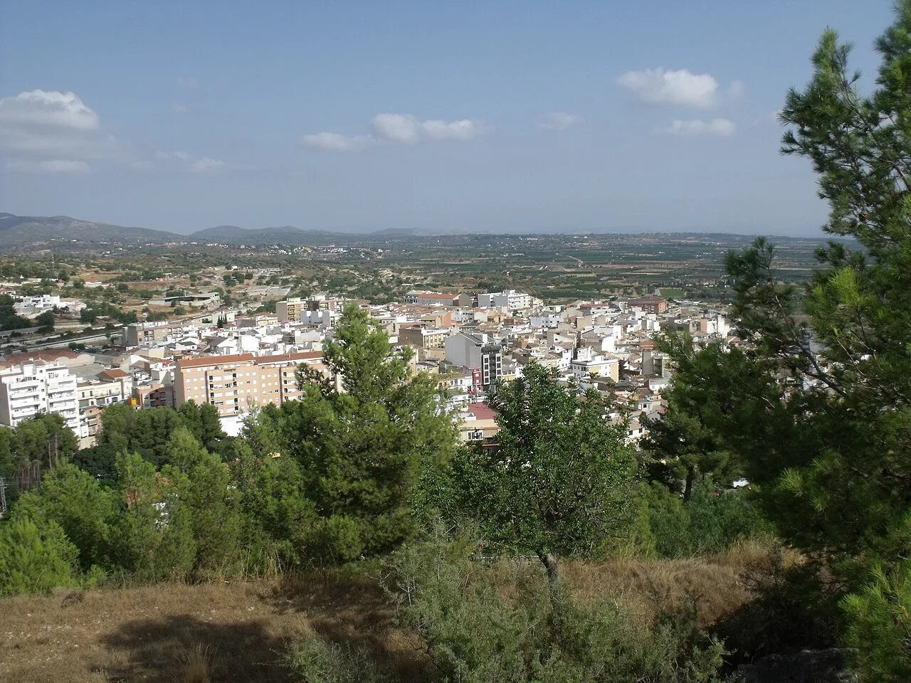 Blick auf Chiva vom Schloss mit Bäumen und Stadt in der Ferne.