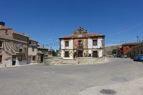 Town hall of Cobos de Cerrato with bunting in the square.