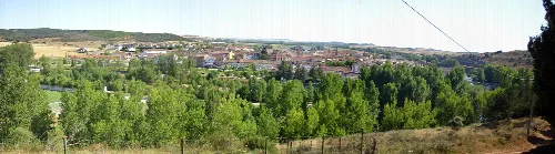 Panoramic view of Alar del Rey from the Portillo, with houses and trees.