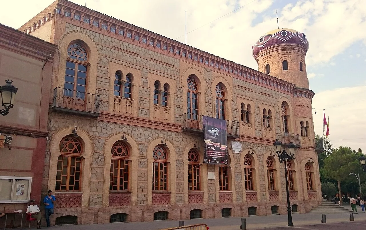 Edificio del ayuntamiento con torreón y ventanas arqueadas en Mora.
