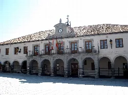 Rathaus mit Bögen im Erdgeschoss und Uhr im Turm.