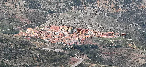 Blick auf die Stadt Camarena de la Sierra in einer bergigen Gegend.
