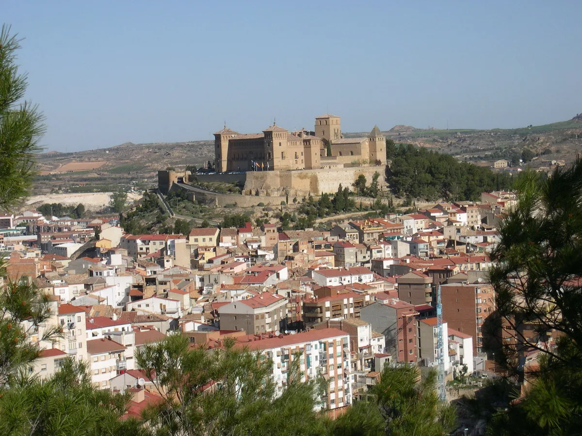 Panoramablick auf Alcañiz mit der Burg auf dem Hügel und Gebäuden im Vordergrund.