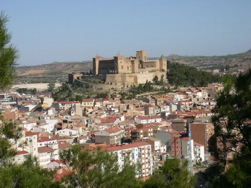 Panoramablick auf Alcañiz mit der Burg auf dem Hügel und Gebäuden im Vordergrund.