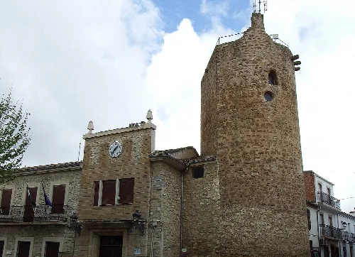 Steinturm mit Uhr und bewölktem Himmel in Lupión.