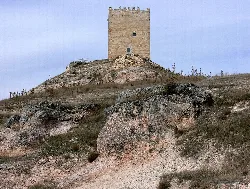 Stone tower on a hill with arid landscape.