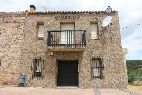 Town hall made of stone with balcony and barred windows in El Ordial.